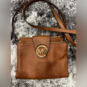 Tan slightly used multiple compartment Micheal Kors crossbody bag